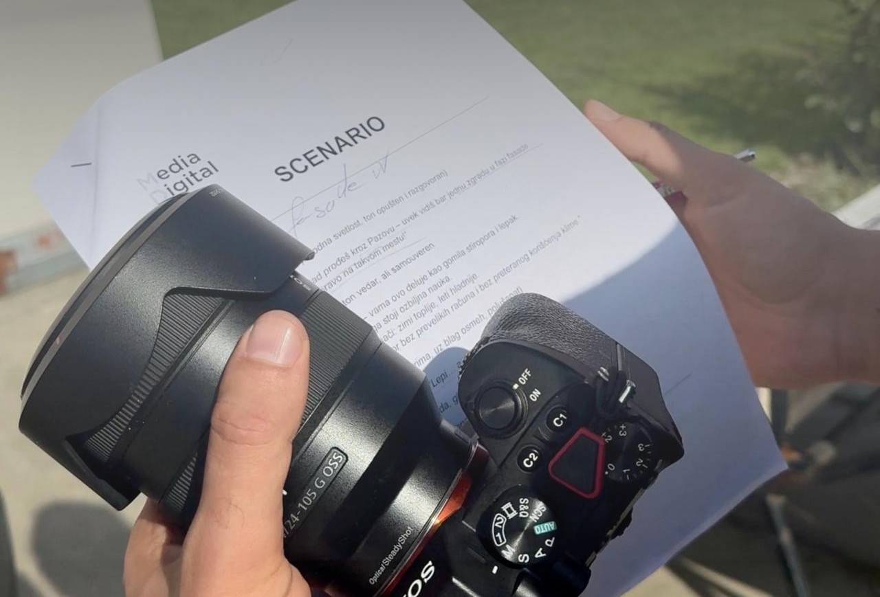 Slika sa terena kako drži scenario i kameru